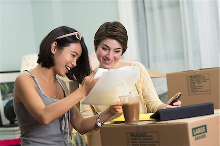 Two young women looking at paperwork for new apartment Foto de stock - Sin royalties Premium, Código: 614-06336113