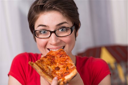 satisfaction eating - Young woman eating a slice of pizza Stock Photo - Premium Royalty-Free, Code: 614-06336130