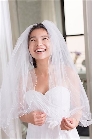 Jeune femme portant robe de mariée et rire Photographie de stock - Premium Libres de Droits, Code: 614-06336142