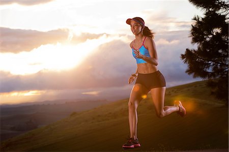 Young woman running in rural setting at sunrise Foto de stock - Sin royalties Premium, Código: 614-06336227