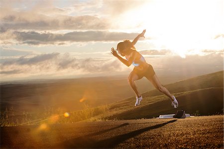 endurance - Young woman moving off starting blocks in rural setting Stock Photo - Premium Royalty-Free, Code: 614-06336228