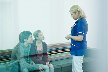 Young couple with nurse in hospital waiting room Stock Photo - Premium Royalty-Free, Code: 614-06336265