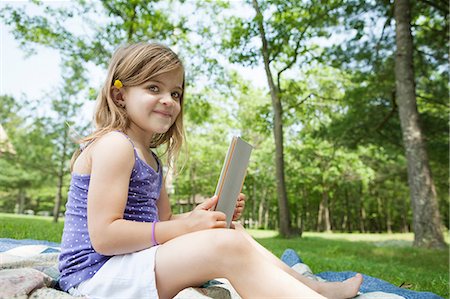 Girl sitting on picnic blanket with digital tablet Stock Photo - Premium Royalty-Free, Code: 614-06336319