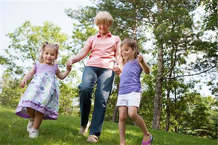 sisters playing in grass - Grandmother and granddaughters holding hands Stock Photo - Premium Royalty-Free, Code: 614-06336313
