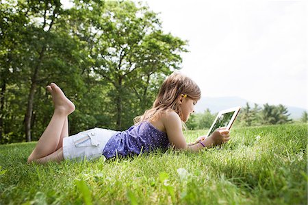 Girl lying on grass with digital tablet Foto de stock - Sin royalties Premium, Código: 614-06336321