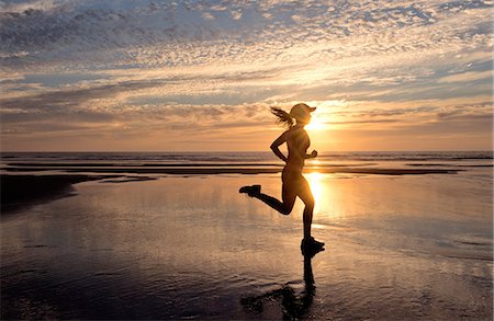 runner silhouette - Woman running on beach at sunrise Stock Photo - Premium Royalty-Free, Code: 614-06336431