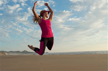 simsearch:614-07486968,k - Young woman jumping in the air on beach Fotografie stock - Premium Royalty-Free, Codice: 614-06336441