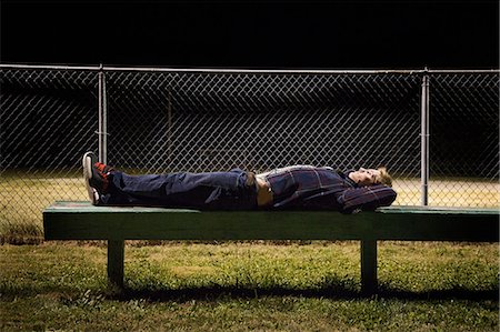 sleeping teens - Young man lying on bleachers at night Stock Photo - Premium Royalty-Free, Code: 614-06402593