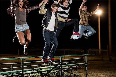 Four friends jumping over bleachers at night Stock Photo - Premium Royalty-Free, Code: 614-06402601