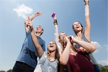 smiling looking up - Five friends cheering, low angle Stock Photo - Premium Royalty-Free, Code: 614-06402610