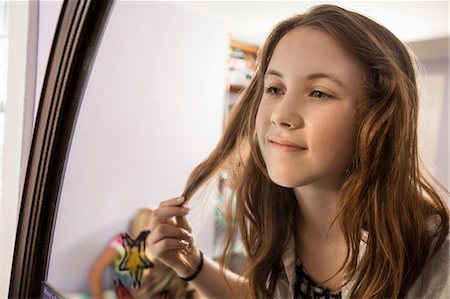 preteen 13 years pic - Girl looking in mirror, touching hair Stock Photo - Premium Royalty-Free, Code: 614-06402663