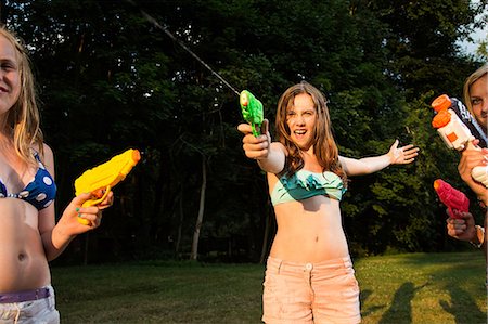 simsearch:614-06402685,k - Girls having water fight with water pistols Stock Photo - Premium Royalty-Free, Code: 614-06402674