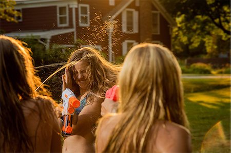 Girls having water fight with water pistols Foto de stock - Royalty Free Premium, Número: 614-06402682