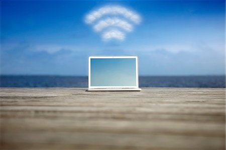 Laptop with wifi symbol at the coast Stock Photo - Premium Royalty-Free, Code: 614-06402726