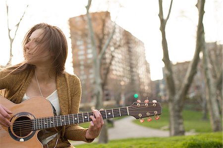 Young woman playing guitar outdoors Fotografie stock - Premium Royalty-Free, Codice: 614-06402734