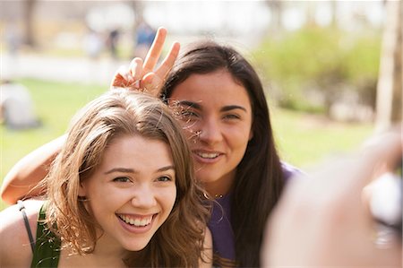 people candid happy - Two young women having their picture taken Stock Photo - Premium Royalty-Free, Code: 614-06402744