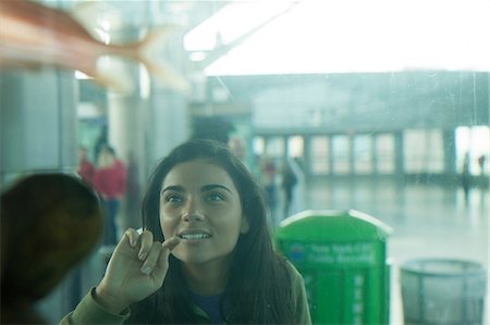 finger pointing and touching not illustration and one person - Young woman looking into an aquarium Stock Photo - Premium Royalty-Free, Code: 614-06402770