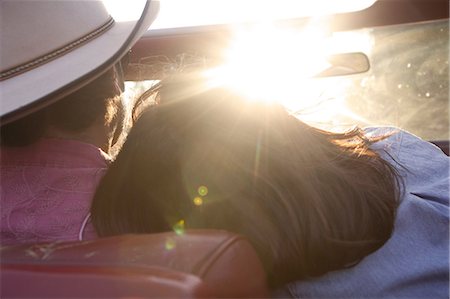 Woman resting head on boyfriend's shoulder as he drives in sunlight Foto de stock - Sin royalties Premium, Código: 614-06402855