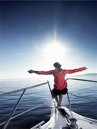 Femme sur la proue du bateau à voile avec les bras tendus Photographie de stock - Premium Libres de Droits, Code: 614-06402871