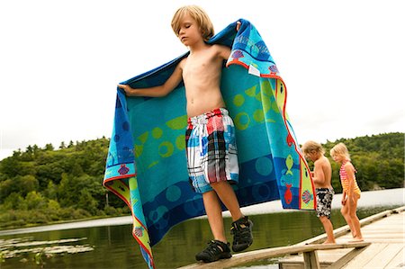 photos of boys short pants - Boy on a pier with towel Stock Photo - Premium Royalty-Free, Code: 614-06402883