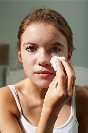 Teenage girl cleansing her face Stock Photo - Premium Royalty-Free, Code: 614-06403032