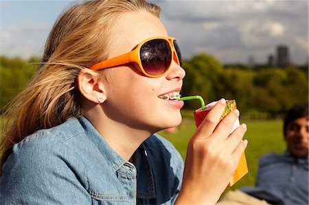 Teenage girl in sunglasses drinking from juice carton Foto de stock - Sin royalties Premium, Código: 614-06403096