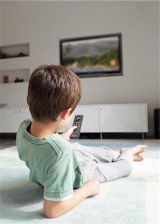 entretenimiento para el hogar - Boy watching television at home Foto de stock - Sin royalties Premium, Código: 614-06442278