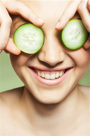 Woman covering eyes with cucumber Foto de stock - Sin royalties Premium, Código: 614-06442366