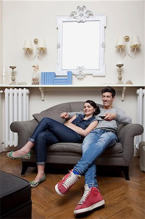 Couple watching tv on sofa Stock Photo - Premium Royalty-Free, Code: 614-06442397