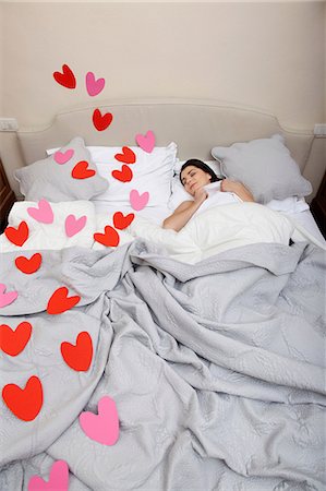 simsearch:614-06442404,k - Woman asleep in bed with heart shapes on bedclothes Foto de stock - Sin royalties Premium, Código: 614-06442393