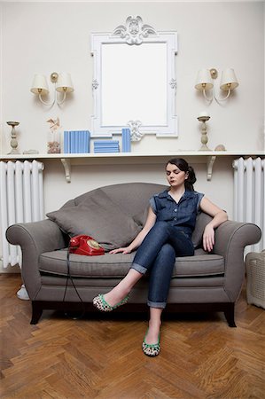 sitting cross legged - Woman on sofa with telephone Stock Photo - Premium Royalty-Free, Code: 614-06442427