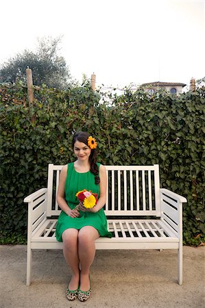 Woman on bench holding flowers Stock Photo - Premium Royalty-Free, Code: 614-06442420