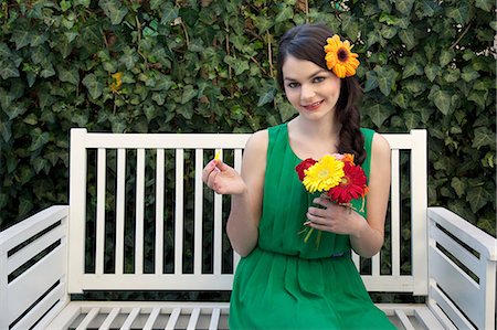Woman on bench holding flowers Stock Photo - Premium Royalty-Free, Code: 614-06442438