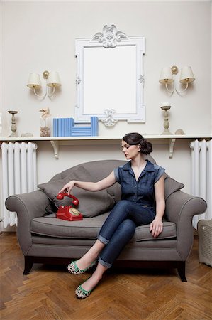 Femme sur le canapé, combiné de téléphone Photographie de stock - Premium Libres de Droits, Code: 614-06442446