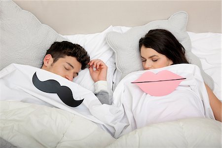 sleeping couple on the bed - Couple au lit avec des lèvres et de la moustache Photographie de stock - Premium Libres de Droits, Code: 614-06442443