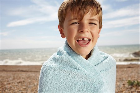 Boy at the beach, wrapped in a towel Stock Photo - Premium Royalty-Free, Code: 614-06442484