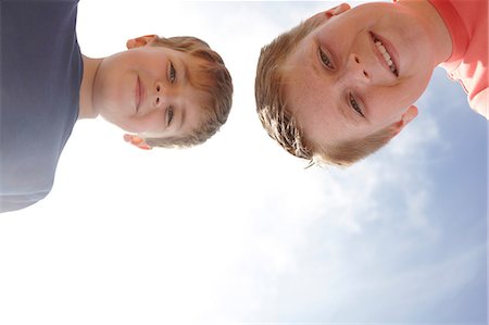 people looking up sky - Two boys looking at camera, viewed from below Stock Photo - Premium Royalty-Free, Code: 614-06442485