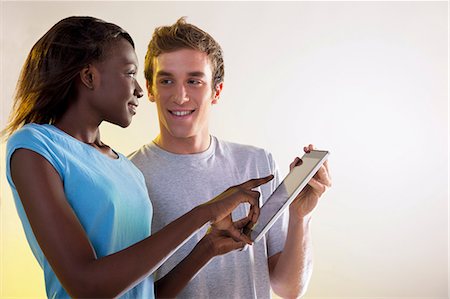 Teenage girl and young man using digital tablet Stock Photo - Premium Royalty-Free, Code: 614-06442503