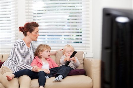 Mother with two children watching television Stock Photo - Premium Royalty-Free, Code: 614-06442555