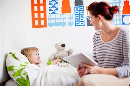 sick - Mother holding digital tablet, daughter in bed Stock Photo - Premium Royalty-Free, Code: 614-06442572