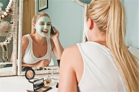 dressing table mirror - Woman in face mask on the phone Stock Photo - Premium Royalty-Free, Code: 614-06442631