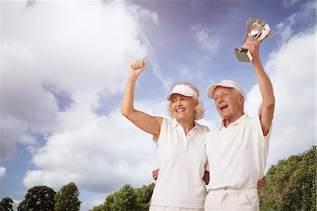 senior tennis - Senior couple holding tennis trophy and cheering Stock Photo - Premium Royalty-Free, Code: 614-06442673