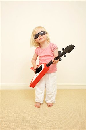 sunglasses girl - Toddler wearing sunglasses, playing guitar Stock Photo - Premium Royalty-Free, Code: 614-06442835