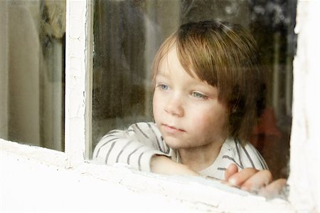 Little boy looking through window Stock Photo - Premium Royalty-Free, Code: 614-06442850