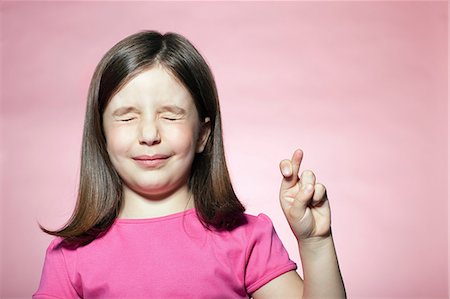 Girl with fingers crossed Stock Photo - Premium Royalty-Free, Code: 614-06442890