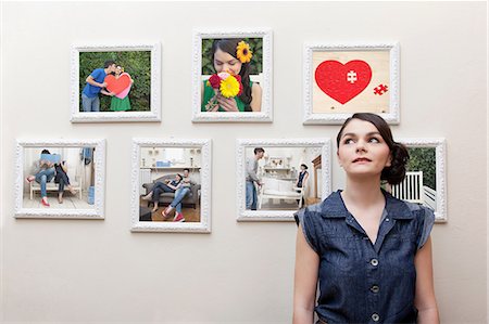 picture frame - Young woman in front of wall of photographs Stock Photo - Premium Royalty-Free, Code: 614-06442906