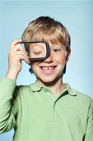 funny and boy - Boy holding smartphone over eye Stock Photo - Premium Royalty-Free, Code: 614-06442909