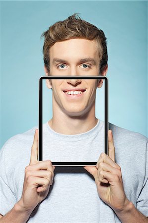 funny people happy caucasian - Man covering half his face with digital tablet Foto de stock - Sin royalties Premium, Código: 614-06442916