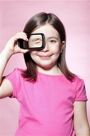 eyes covered - Girl holding smartphone over eye Stock Photo - Premium Royalty-Free, Code: 614-06442911