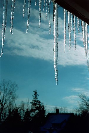 dangling - Icicles under roof eaves against winter sky Foto de stock - Sin royalties Premium, Código: 614-06442950